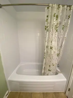 a white bath tub with a shower curtain in a bathroom at 2-3 Bedroom Friends or Family Dwelling in Brampton