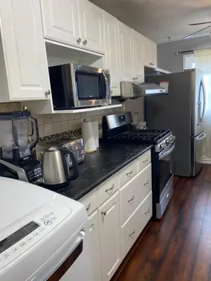 a kitchen with white cabinets and stainless steel appliances at 2-3 Bedroom Friends or Family Dwelling in Brampton