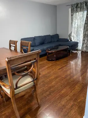 a living room with a blue couch and a table at 2-3 Bedroom Friends or Family Dwelling in Brampton