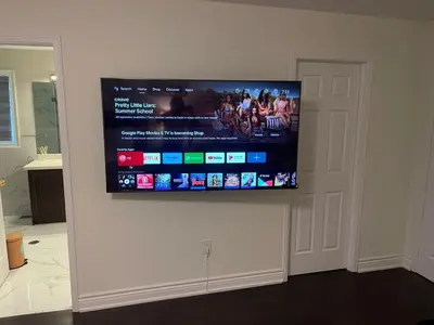 a flat screen tv hanging on a wall at Grandeur Homes in Whitby