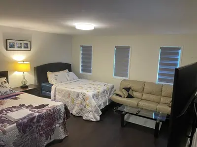 a hotel room with a bed and a couch and a bed and a couch at Grandeur Homes in Whitby
