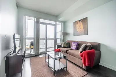 a living room with a couch and a glass table at Modern 1 Bedroom Dunfield Ave Apartment in Toronto
