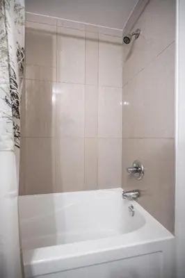 a bathroom with a bath tub with a shower at Modern 1 Bedroom Dunfield Ave Apartment in Toronto