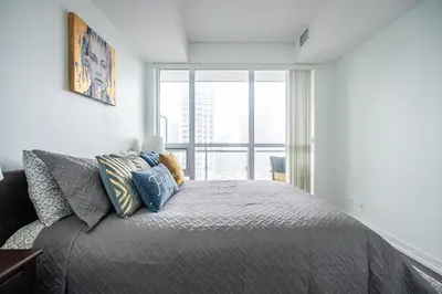 a bedroom with a bed and a large window at Modern 1 Bedroom Dunfield Ave Apartment in Toronto
