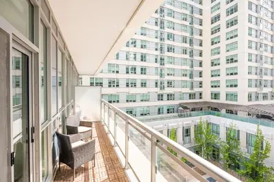 a balcony with chairs and a large building at Modern Apartments 2BR 2BA Lillian St with Balcony in Toronto