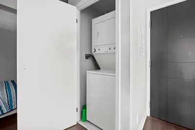 a kitchen with a washer and dryer in a room at Modern 1Bd & Den Condo with Balcony Lillian St in Toronto