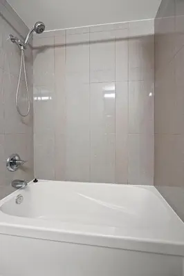 a shower in a bathroom with a white tub at Modern 1Bd & Den Condo with Balcony Lillian St in Toronto