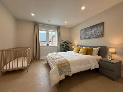 a bedroom with a crib and a large bed at Prestige 3BR Luxury Living in Queen West in Toronto