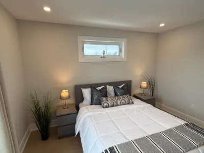 a bedroom with a bed with two lamps and a window at Prestige 3BR Luxury Living in Queen West in Toronto