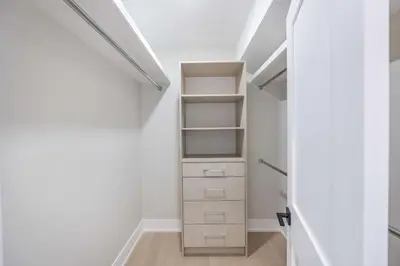 a walk in closet with white walls and white shelves at Prestige 3BR Luxury Living in Queen West in Toronto