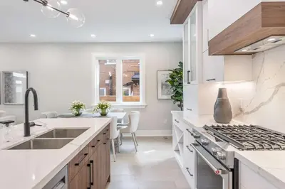 a white kitchen with a sink and a stove at Prestige 3BR Luxury Living in Queen West in Toronto