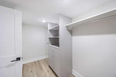 a bedroom with white walls and a closet with shelves at Stylish 1BR in Queen West in Toronto