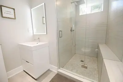 a white bathroom with a shower and a sink at Stylish 1BR in Queen West in Toronto