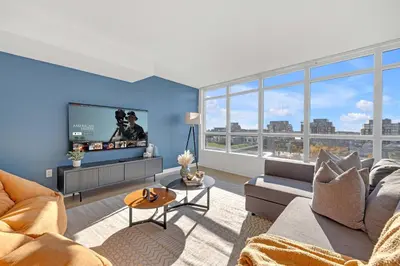 a living room with a couch and a flat screen tv at Spacious Retreat Luxe 3BR Condo with City Views in Toronto