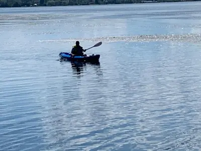 a person in a kayak in a large body of water at Luxurious Lakefront Cottage, Sleeps 12 in Bewdley