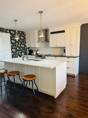 a kitchen with white cabinets and a counter with stools at Luxurious Lakefront Cottage, Sleeps 12 in Bewdley