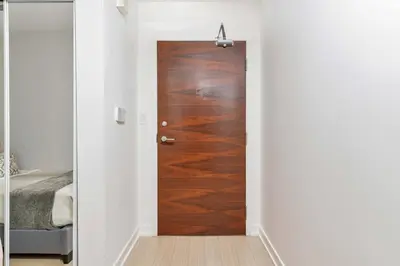 a hallway with a wooden door in a bedroom at Charming Condo w Private Patio in Quiet Capreol in Toronto