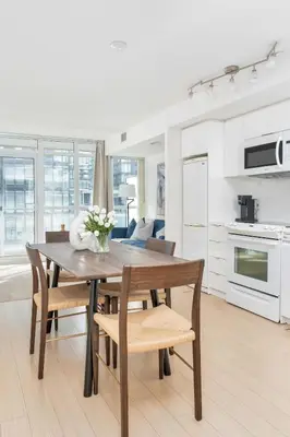 a kitchen and dining room with a table and chairs at Charming Condo w Private Patio in Quiet Capreol in Toronto