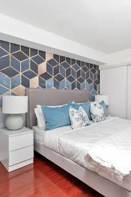 a bedroom with a large bed with blue pillows at Charming Condo w Private Patio in Quiet Capreol in Toronto