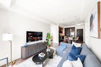 a living room with a blue couch and a tv at Modern 2BR in TO Near Yorkville & the Village in Toronto