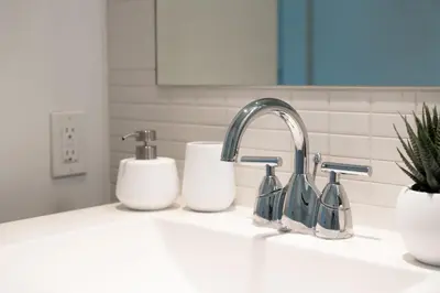 a kitchen counter with a sink with two soap dispensers at Modern 2BR in TO Near Yorkville & the Village in Toronto