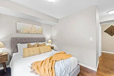 a bedroom with a large bed with white walls at Modern Oasis Stylish 2BR Condo Near Attractions in Toronto