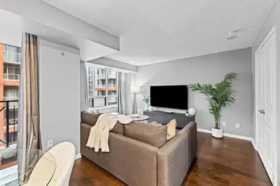 a living room with a couch and a flat screen tv at Modern Oasis Stylish 2BR Condo Near Attractions in Toronto