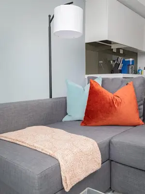 a gray couch with orange and blue pillows on it at Toronto Getaway 2BR Condo w City Views in Toronto