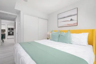 a bedroom with a large bed with blue and white pillows at Toronto Getaway 2BR Condo w City Views in Toronto