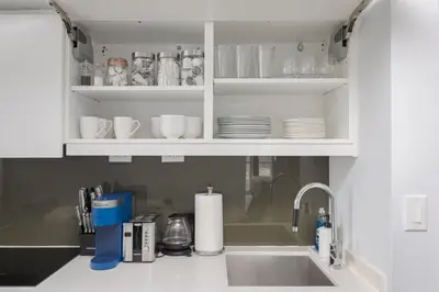 a kitchen counter with a sink and a shelf with dishes at Toronto Getaway 2BR Condo w City Views in Toronto