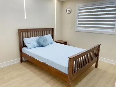 a bed in a bedroom with a clock on the wall at 3 Bedroom Home Peaceful & Trendy in Brampton