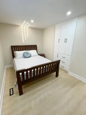a bedroom with a bed with a wooden bed frame at 3 Bedroom Home Peaceful & Trendy in Brampton