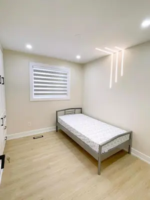 a bedroom with a bed in a room with a window at 3 Bedroom Home Peaceful & Trendy in Brampton