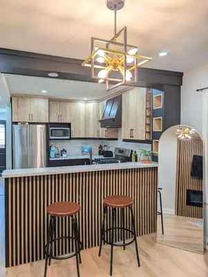 a kitchen with wooden cabinets and a bar with stools at Hamilton Ontario 2 BR Wi-Fi Workspaces Near Ottawa in Hamilton