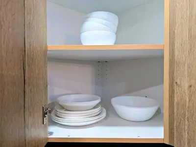 a cabinet with bowls and plates in it at Hamilton Ontario 2 BR Wi-Fi Workspaces Near Ottawa in Hamilton