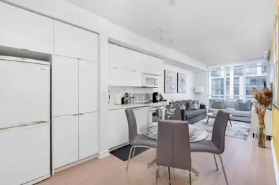 a kitchen and living room with a table and chairs at Modern Waterfront Comfort Condo with City Views in Toronto
