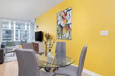 a dining room with a glass table and chairs at Modern Waterfront Comfort Condo with City Views in Toronto