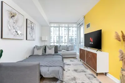 a bedroom with a large bed and a yellow wall at Modern Waterfront Comfort Condo with City Views in Toronto