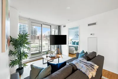 a living room with a couch and a large window at Spacious 3BR Condo w Patio & Skyline Views in Toronto