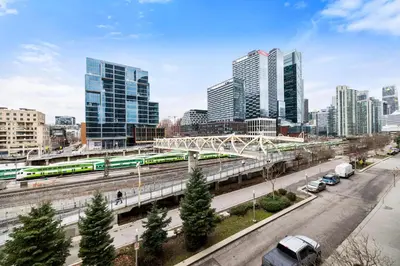 a view of a city with a train on a bridge at Spacious 3BR Condo w Patio & Skyline Views in Toronto
