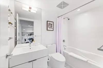 a white bathroom with a sink and a toilet at Modern & Stylish Comfort in the Heart of Toronto in Toronto