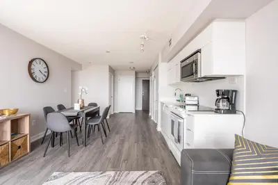 a kitchen and living room with a table and chairs at Corner 2 Bedroom 2 Bathroom Condo Balcony Iceboat Terrace Downtown Toronto in Toronto