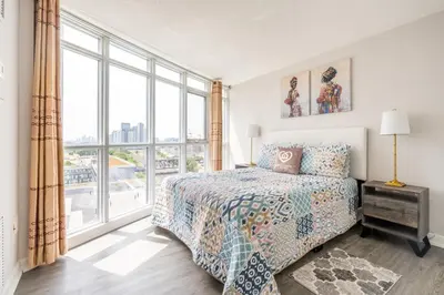 a bedroom with a bed and a large window at Corner 2 Bedroom 2 Bathroom Condo Balcony Iceboat Terrace Downtown Toronto in Toronto