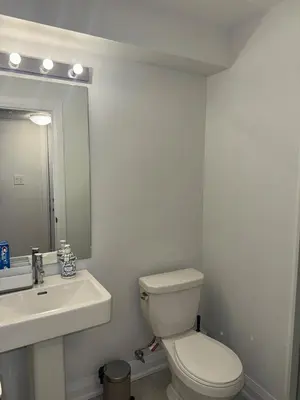 a bathroom with a toilet and a sink and a mirror at Entire unit seprate entrance in Richmond Hill