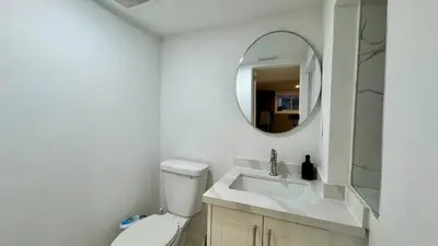 a bathroom with a white toilet and a mirror at Spacious and Luxurious 2BR Suite with Huge Windows in Mississauga