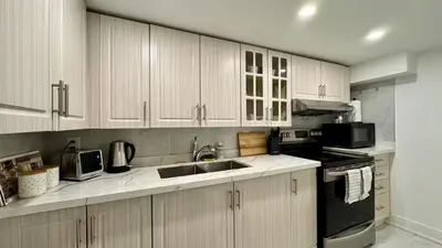a kitchen with white cabinets and a sink at Spacious and Luxurious 2BR Suite with Huge Windows in Mississauga