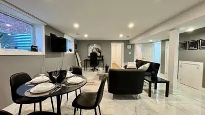 a dining room and living room with a table and chairs at Spacious and Luxurious 2BR Suite with Huge Windows in Mississauga