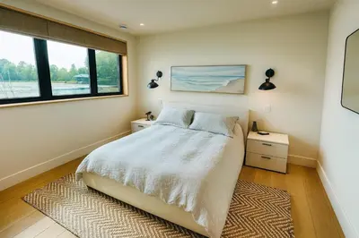 a bedroom with a bed and two windows at Stoney Lake Cottage with Private Dock by Leavetown Vacations in Crowes Landing