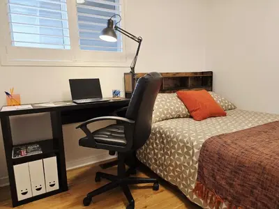 a bedroom with a desk with a laptop and a bed at Semi-Private Townhouse - 3 Bedrooms - 4 beds - Free Parking, Wifi, Netflix in Toronto