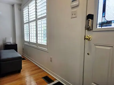 a room with a door and a couch and a window at Semi-Private Townhouse - 3 Bedrooms - 4 beds - Free Parking, Wifi, Netflix in Toronto